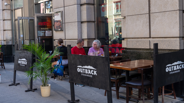 Guests dine outside Outback Steakhouse