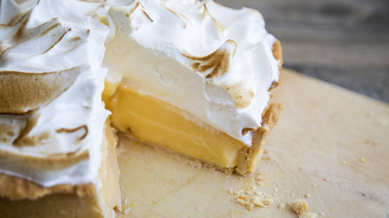 A lemon pie with meringue has a triangular slice missing.