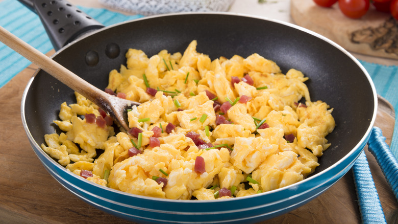 Scrambled eggs sit in a skillet.