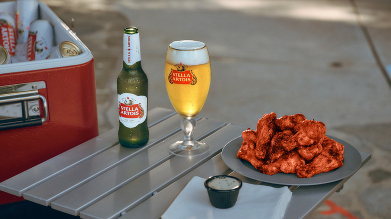 Stella Artois bottles and a plate of buffalo chicken wings