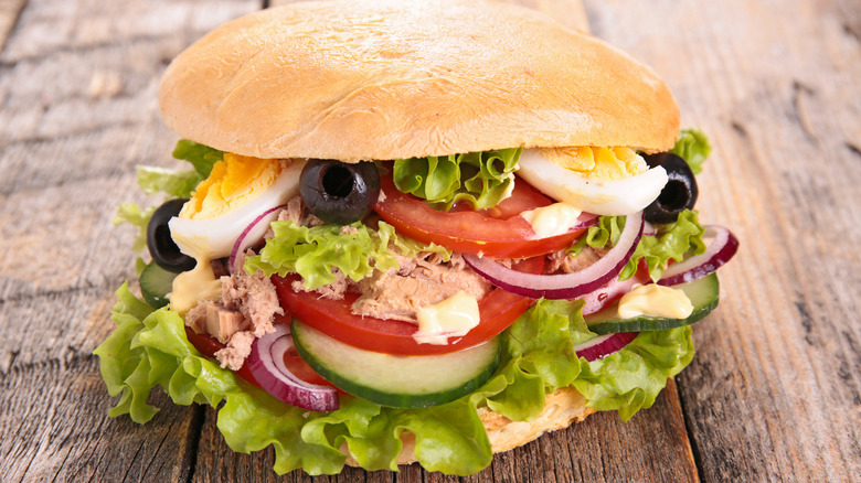 Pan bagnat sandwich on wood background