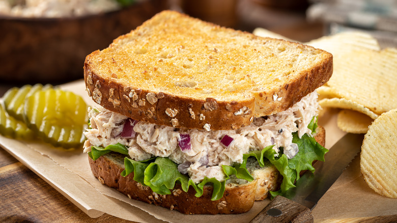 Tuna salad sandwich on toasted bread with chips