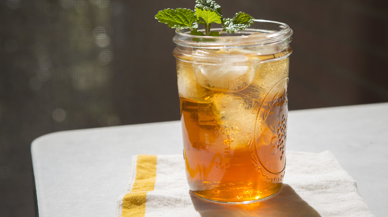 A mason jar of iced tea with a mint garnish