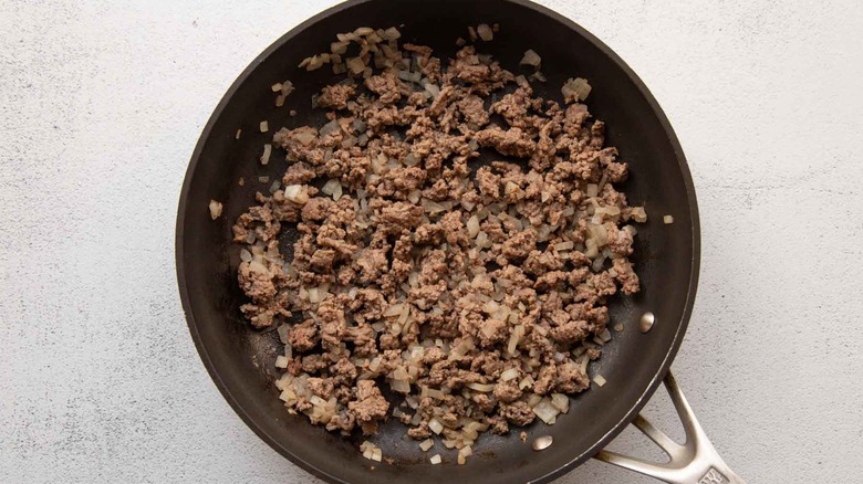 cooked ground beef and onion in skillet