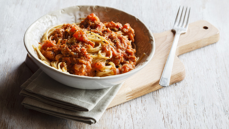 A plate of spaghetti with napkin and fork