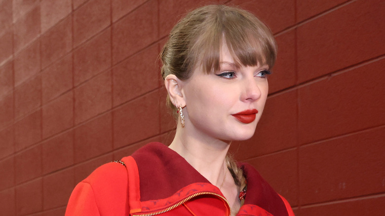 Taylor Swift on red brick background with hair up and red lipstick taken November 29th, 2024