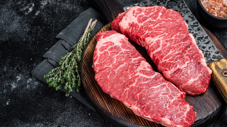 Raw Denver steak on a wooden board