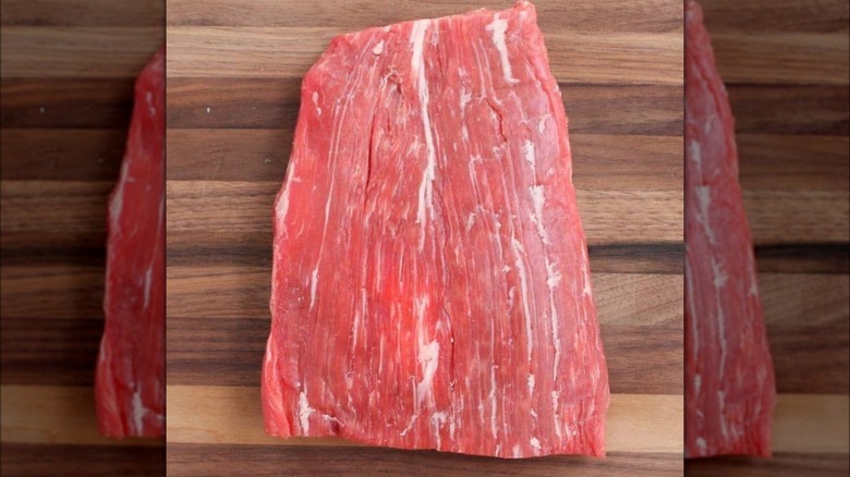 Raw flank steak on cutting board