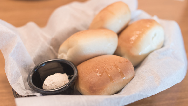 A basket of Texas Roadhouse rolls are shown in a basket