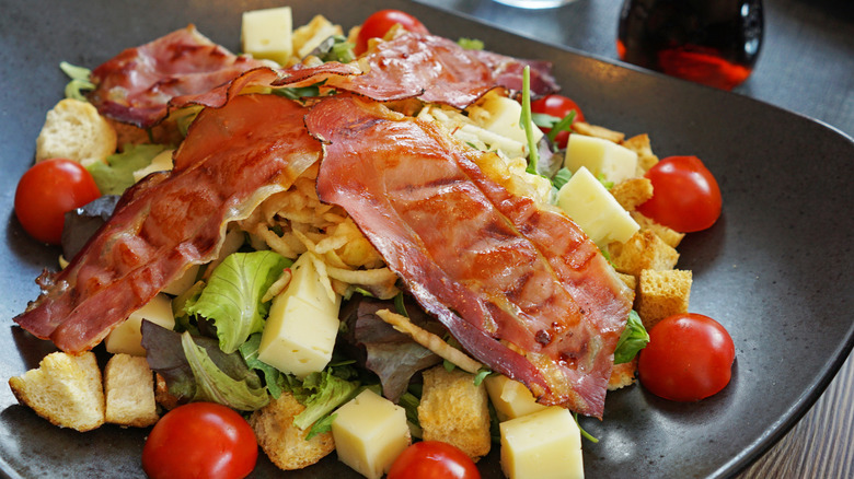 Salad topped with bacon and cheese