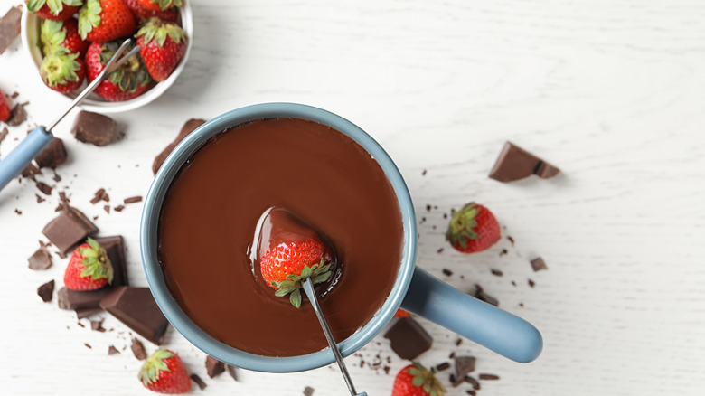 Strawberry being dipped in chocolate fondue