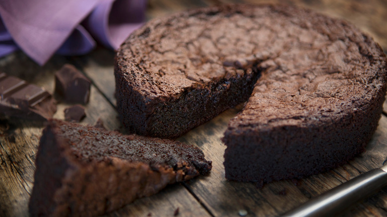 Chocolate cake without any decoration with one slice cut out