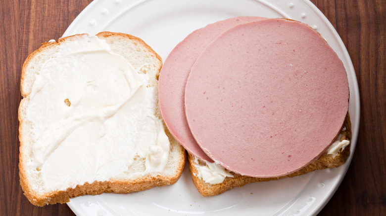 An overhead shot of an open bologna sandwich with mayonnaise