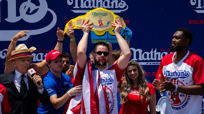 2024 Nathan's Hot Dog Eating champion Patrick Bertoletti holding trophy