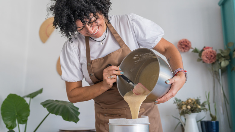 Woman pouring cake mix into pan