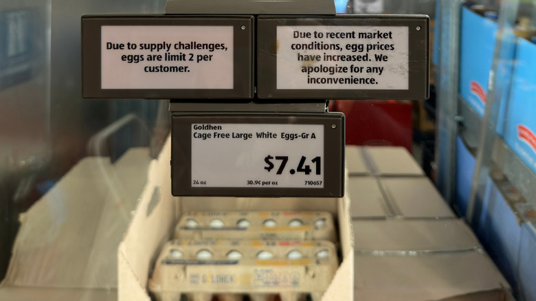 Signs are shown at an Aldi detailing the rising cost of eggs and the limit on egg purchases