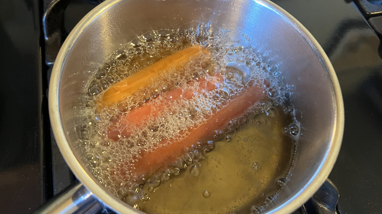 Hot dogs are being deep fried.