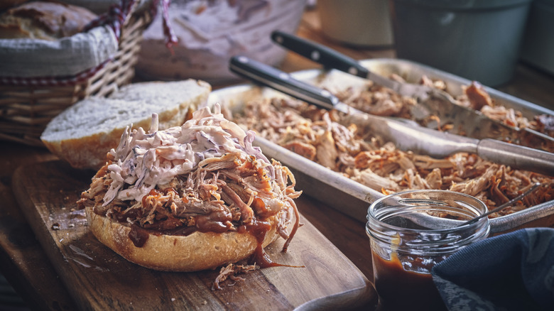 Messy pulled pork sandwich with coleslaw and bbq sauce