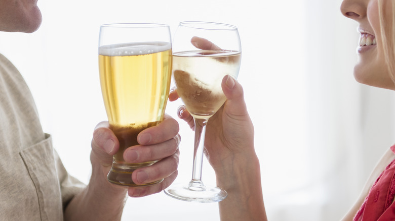 a man and a woman holding wine and beer