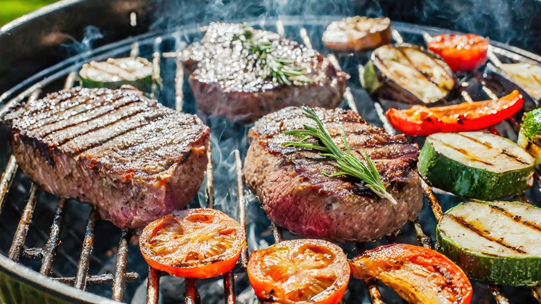 Steak and vegetables cooking on a grill