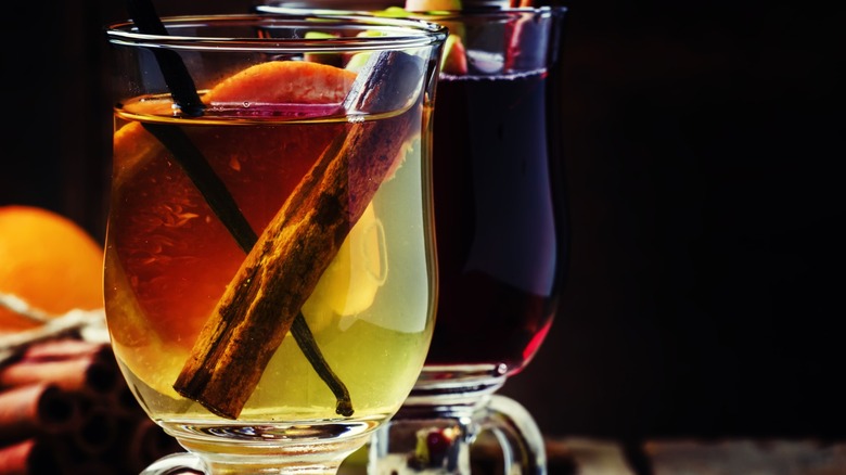 A glass of mulled white wine with a glass of mulled red wine