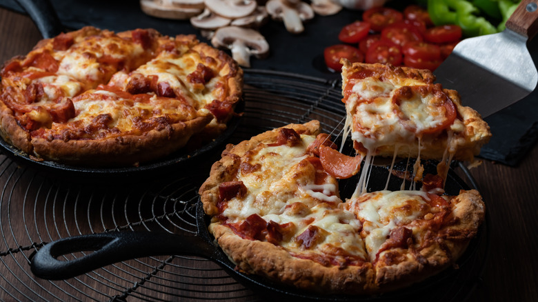 Pizza sliced in cast-iron skillet