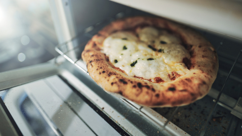 Pizza coming out of toaster oven