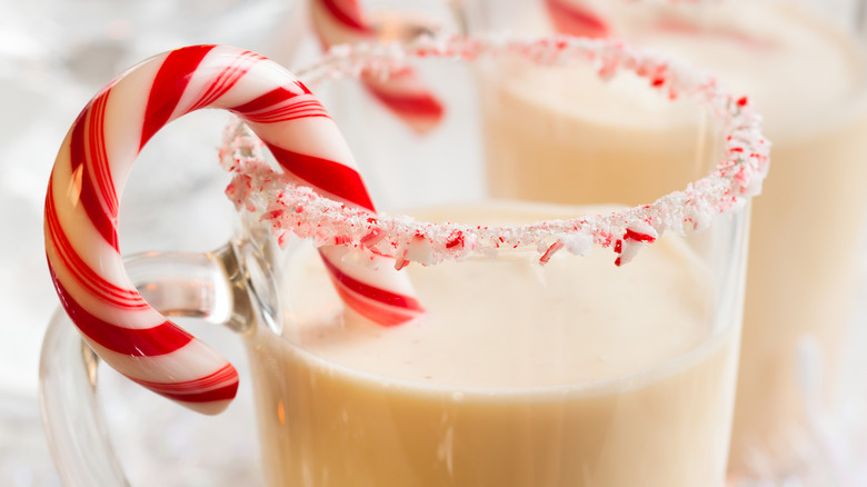 Peppermint rimmed glass of eggnog with candy cane garnish