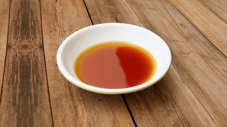 Fish sauce in a white bowl on a wooden surface