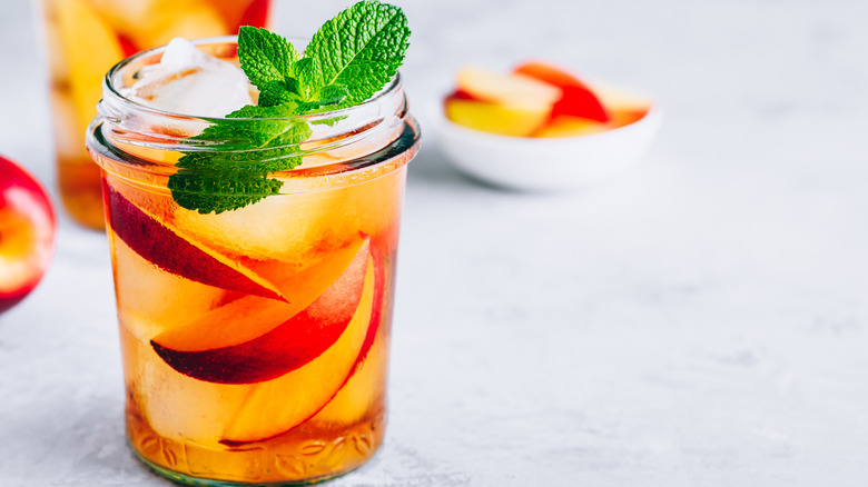 Peach iced tea margarita with mint garnish.