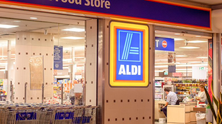 outside looking in view of Aldi store and cashier at register