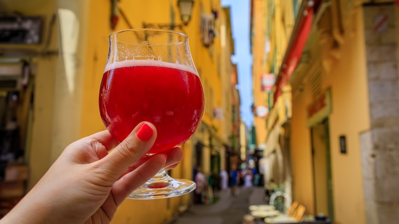 hand holding glass of raspberry lambic