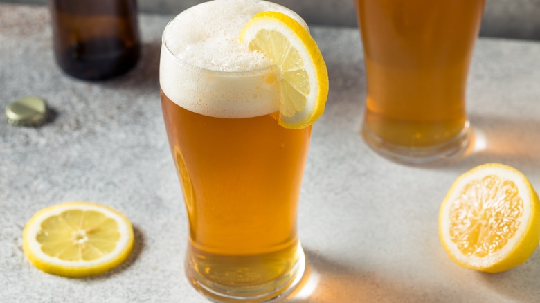 lemon shandy in a pint glass garnished with a lemon wheel