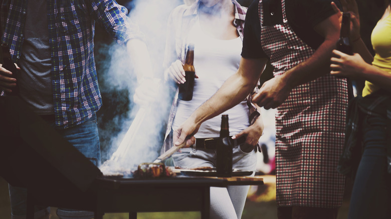 people at barbecue holding beer