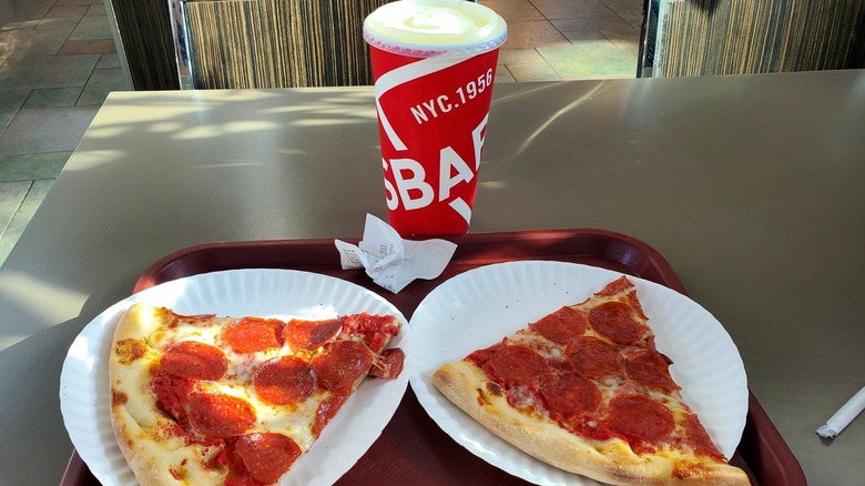 pizza slices on paper plate and drink