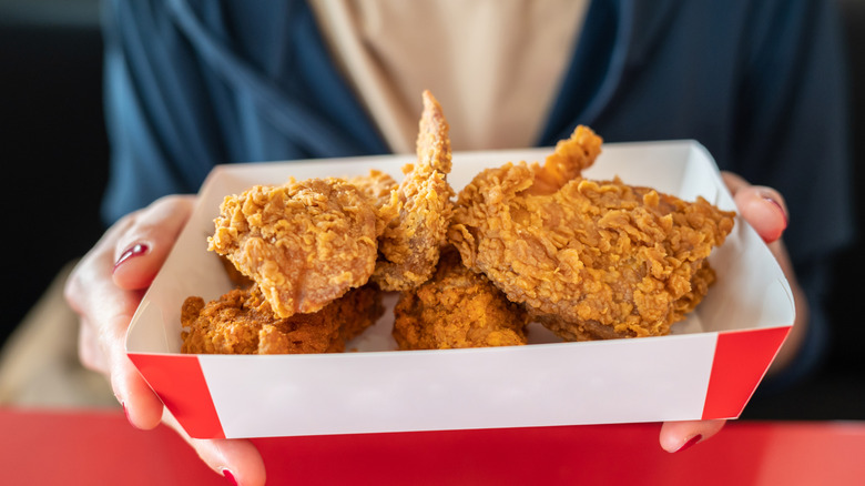 Fried chicken in a white and red cardboard basket