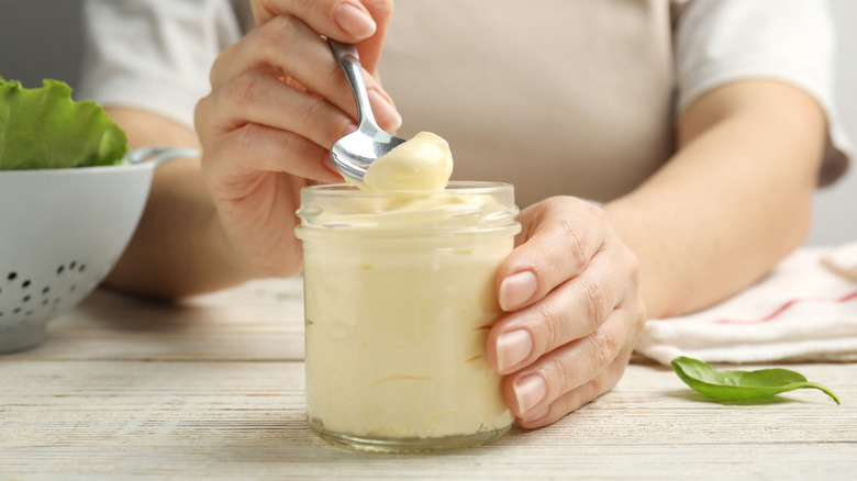 woman scooping mayo