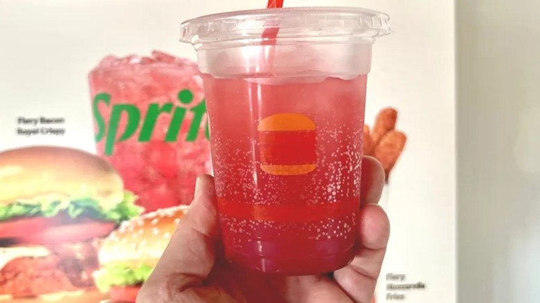 A handheld cup of Burger King's Fiery Strawberry & Sprite