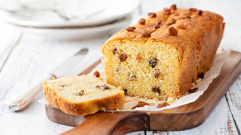 Fruitcake with a slice cut off on a wooden board