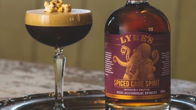 bottle of Lyre's zero-proof rum alternative with a cocktail