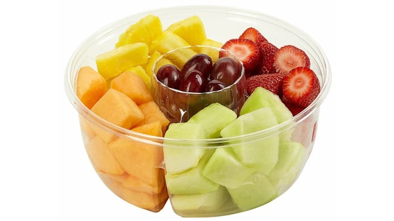 Plastic fruit bowl with melon, pineapple, strawberries, and grapes