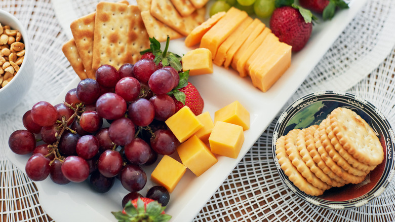 Party appetizers including cheese, fruit, and crackers