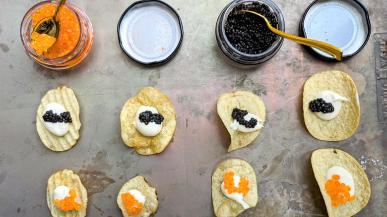 Assortment of potato chips, top view, with jars of caviar