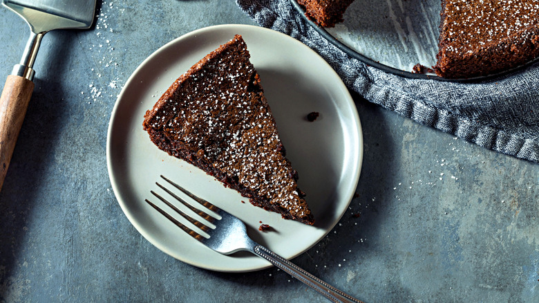 A slice of chocolate cake made with olive oil on a plate with a fork