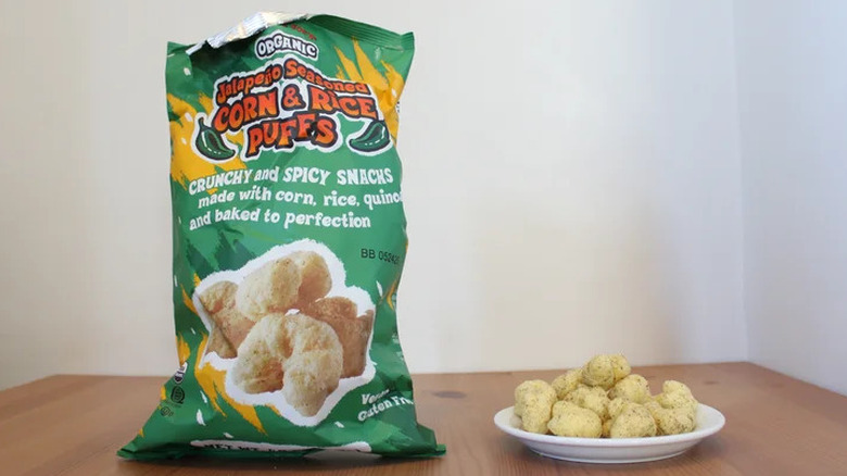 Trader Joe's jalapeño-seasoned corn and rice puffs alongside bags of the product.