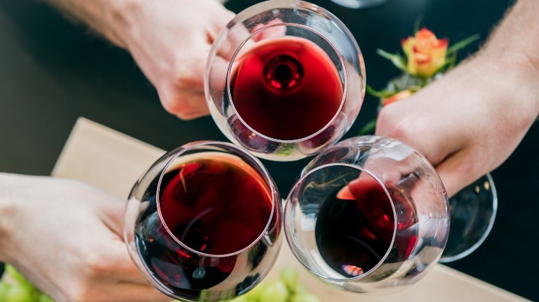 A close-up of three wine glasses clinking.