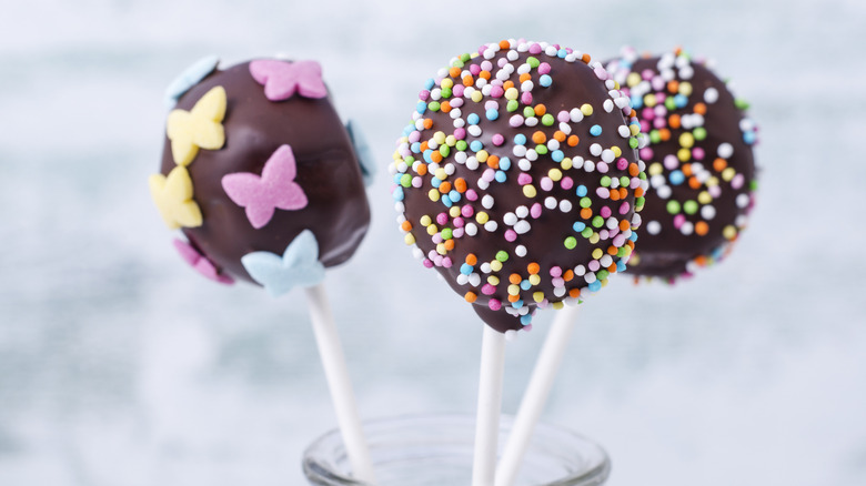 Three chocolate cake pops with sprinkles