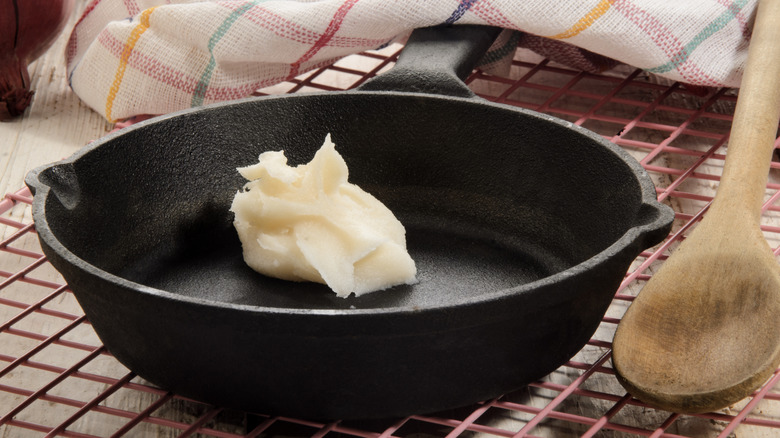 Spoonful of solidified pork fat in cast iron pan