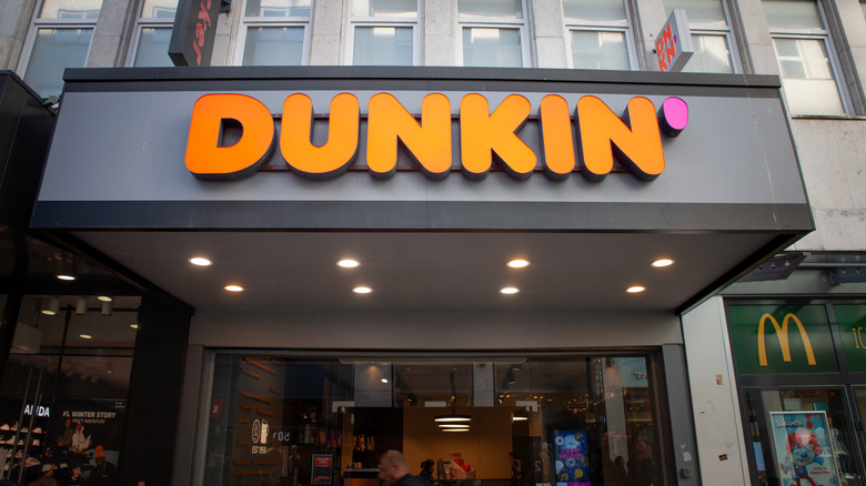 The exterior of a Dunkin' location in a city