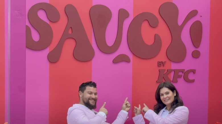 couple posing by sign at kfc saucy